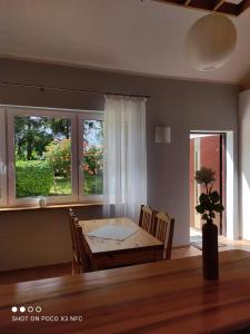 a dining room with a table and two windows at Chata Pod Różą in Lędzin