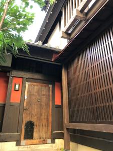 uma porta de madeira na lateral de um edifício em Guest House Dohei em Kamakura