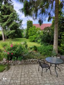 a patio with a table and chairs in a garden at Chata Pod Różą in Lędzin