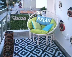 a porch with a wicker chair on a balcony at Seaside BLISS in Agia Triada