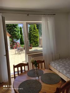 a dining room table with two chairs and a window at Chata Pod Różą in Lędzin +38 photos