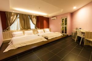 a large bedroom with two beds and a table at JS Hotel in Johor Bahru