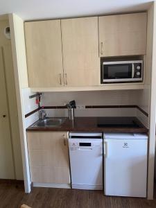 a small kitchen with a sink and a microwave at Cap Esterel 2 pièces Climatisé 4-5pers Piscines Parking Draps Wifi in Saint-Raphaël