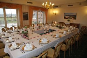 una grande sala da pranzo con un lungo tavolo e sedie di Flair Seehotel Zielow a Ludorf