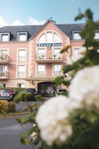 ein Hotel mit davor geparkt in der Unterkunft Tulip Inn Honfleur Residence & Spa in Honfleur