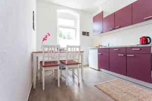 a kitchen with purple cabinets and a table and chairs at FullHouse - Chemnitz - Z25 Apartments - 3 Beds - SmartTV - Nespresso in Chemnitz