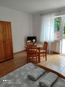 a living room with a table and chairs and a dining room at Chata Pod Różą in Lędzin