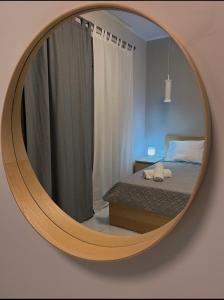 um espelho circular num quarto com uma cama em SEA HORIZON SUITES em Chalkida