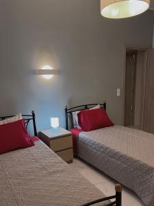 sypialnia z 2 łóżkami i czerwonymi poduszkami w obiekcie SEA HORIZON SUITES w Chalkidzie