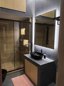 La salle de bains est pourvue d'un lavabo noir et d'une douche. dans l'établissement SEA HORIZON SUITES, à Chalcis