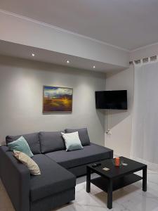 sala de estar con sofá y TV de pantalla plana en SEA HORIZON SUITES, en Chalkida
