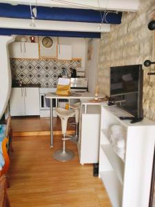 kuchnia ze stołem i krzesłami w pokoju w obiekcie studio coconning proche de Fouras w mieście Saint-Laurent-de-la-Prée