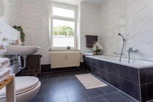 a bathroom with a tub and a sink and a toilet at FullHouse - Chemnitz - Z25 Apartments - 3 Beds - SmartTV - Nespresso in Chemnitz +55 photos