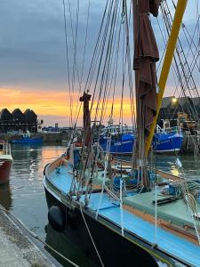 a sailboat docked in a marina at sunset at The Snug- With Private parking in Whitstable