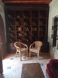 two chairs in a room with book shelves at Riad La Rose Des Vents in Essaouira