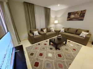 a living room with a couch and a table at Gazzar inn Rehab42 in Madīnat ash Shurūq