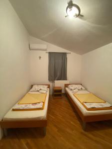 2 Betten in einem kleinen Zimmer mit Fenster in der Unterkunft Spirit in Međugorje