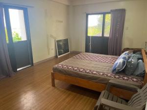 een slaapkamer met een bed, een stoel en een raam bij Beautiful 3 bedroom vacation home with view. in Zamboanga