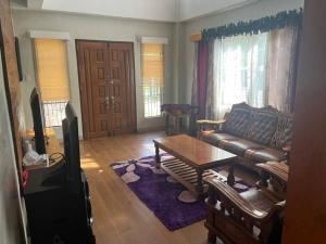 a living room with a couch and a table at Beautiful 3 bedroom vacation home with view. in Zamboanga