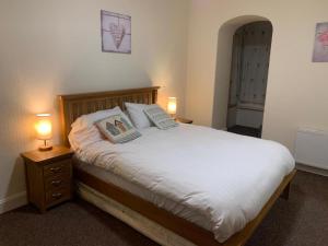 a bedroom with a bed with two pillows and two lamps at Cutty Sark Inn in Eyemouth