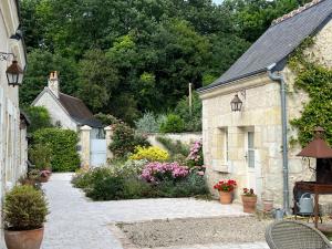 ein Steinhaus mit einem Garten mit Blumen in der Unterkunft la Chambre des Dames in Vallères