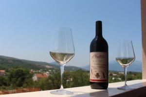 a bottle of white wine next to two wine glasses at Jovan Vukovic in Kotor