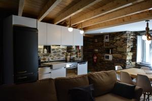 a living room with a couch and a kitchen at Casa do Azereiro in Casal do Rei