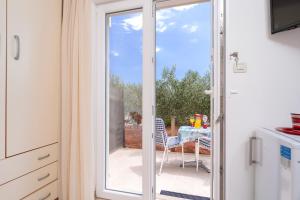 a sliding glass door leading to a patio with a table at Villa Fio - Rooms & Studio in Hvar