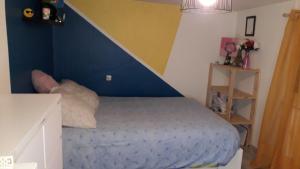 a bedroom with a blue bed with a blue wall at location pour 24h du mans in Arnage