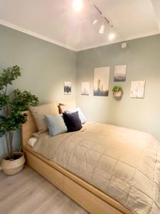 een slaapkamer met een groot bed met kussens erop bij Apartment «Ladegården» in Bergen in Bergen