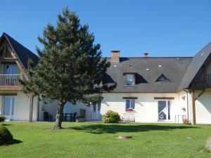 una gran casa blanca con un árbol en el patio en Omaha gîtes, en Vierville-sur-Mer