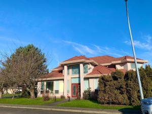 a house with a red roof on a street at One Bedroom queen bed Sharing Washroom in Tiger Sweet House License## in Richmond