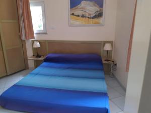 a bedroom with two blue beds in a room at Calarossa Village in Isola Rossa