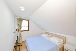 a white bedroom with a bed and a window at Filipa River House Ada Bojana in Ulcinj