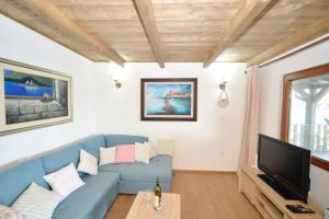 a living room with a blue couch and a tv at Filipa River House Ada Bojana in Ulcinj