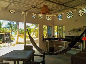 una hamaca en una casa con mesa y cocina en Aldea Playa Real, en Moñitos