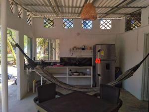 Una habitación con una hamaca en una cocina con nevera. en Aldea Playa Real, en Moñitos