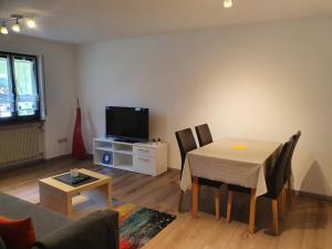 ein Wohnzimmer mit einem Tisch und einem TV in der Unterkunft Haus am Eckle in Kleines Wiesental