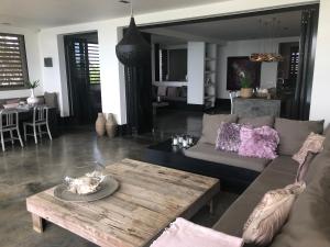 ein Wohnzimmer mit Sofa und Tisch in der Unterkunft OCEANFRONT VILLA WITH ACCES CARIBBEAN SEA in Kralendijk