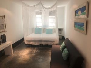 ein Schlafzimmer mit einem Bett mit blauen Kissen und einem Fenster in der Unterkunft OCEANFRONT VILLA WITH ACCES CARIBBEAN SEA in Kralendijk