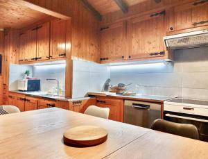 a kitchen with wooden cabinets and a wooden table at La Clusaz Ski aux pieds in La Clusaz