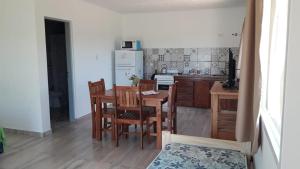 a kitchen with a table and chairs and a refrigerator at Soles de Alicia in Colón