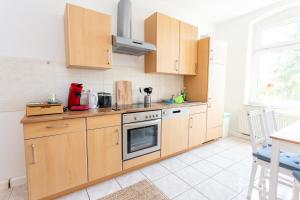 a kitchen with wooden cabinets and a stove top oven at FULL HOUSE Studios - Apartment Namibia in Chemnitz