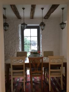 una sala da pranzo con tavolo, sedie e una finestra di Ferienhaus am Eifelsteig a Alendorf