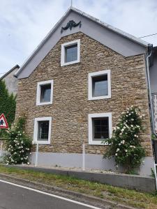 a brick house with white windows on a street at Ferienhaus am Eifelsteig 
