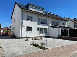 a white house with a driveway in front of it at Messe- und Ferienwohnung Feucht in Feucht