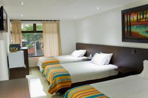 Hotel Acqua Medellín tesisinde bir odada yatak veya yataklar