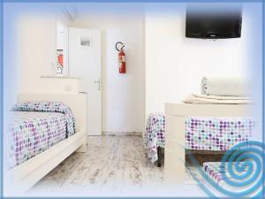 a room with two beds and a tv on a wall at B&B La Terrazza Sul Mare Taormina in Taormina
