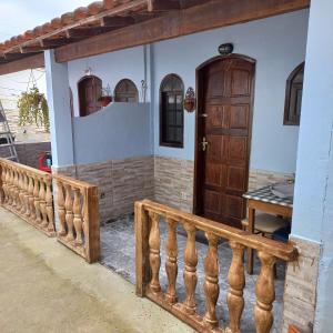 a house with a wooden door and a fence at Vilmar suítes in Maricá