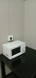 a microwave sitting on top of a black table at Thully Teams in Nelspruit